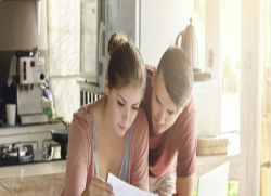 Couple in a Kitchen looking over paper work.